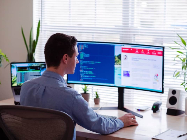 Image showing a web developer in Dubai sitting at a desk, typing on computer with focus and determination.