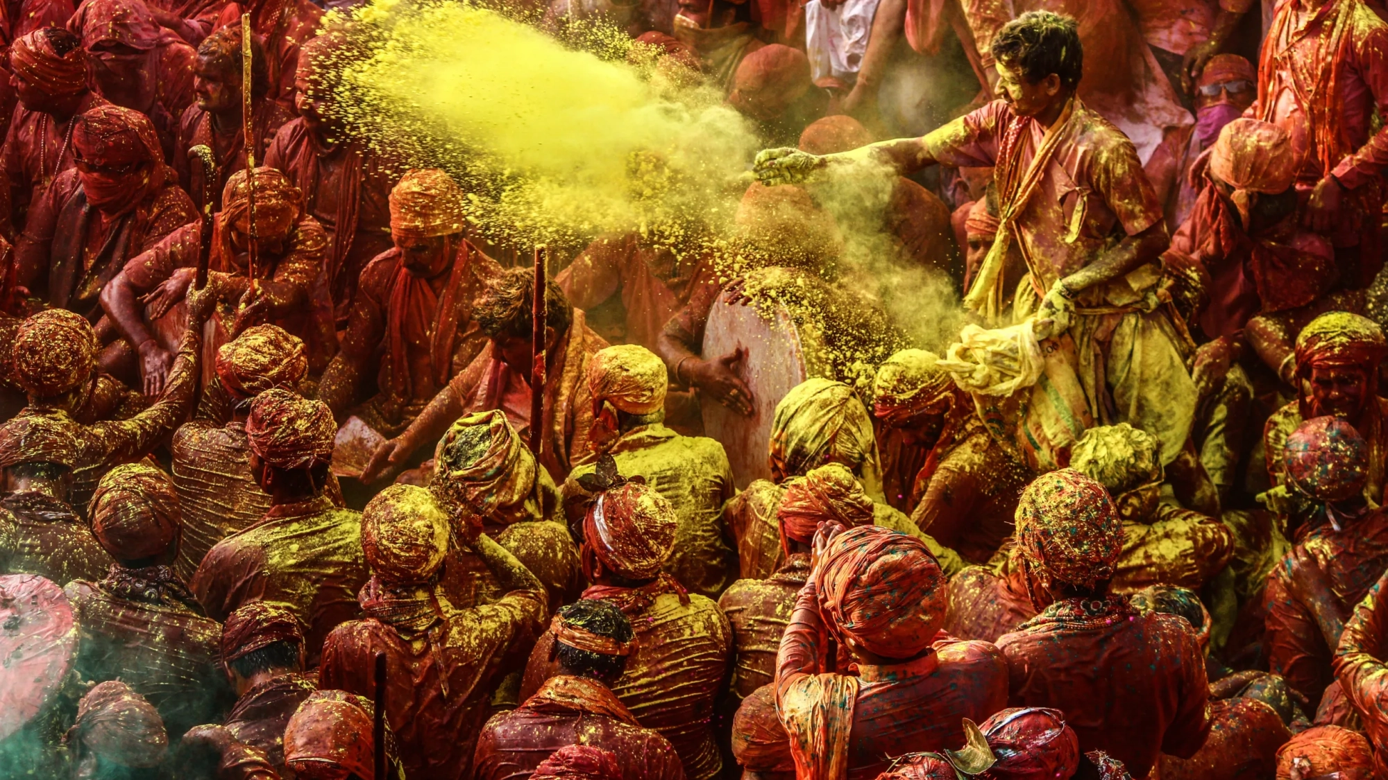 A group of people throwing colored powder during Holi celebration