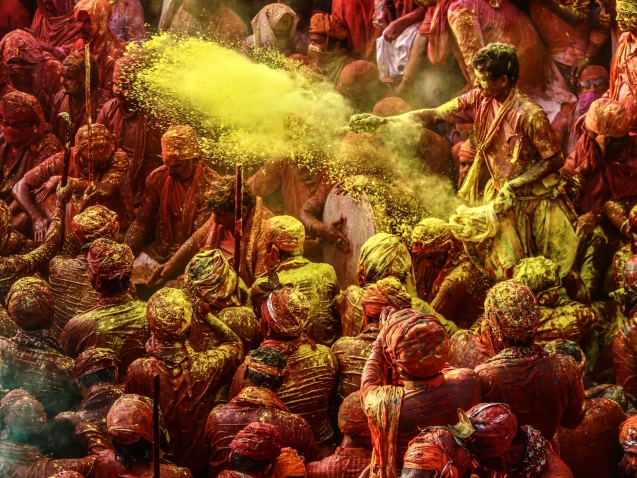 A group of people throwing colored powder during Holi celebration