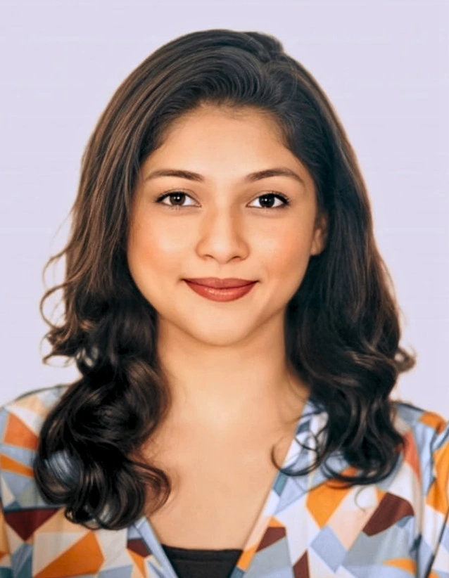 "Portrait of a young woman with shoulder-length wavy dark brown hair, wearing a colorful geometric-patterned top, smiling gently at the camera."
